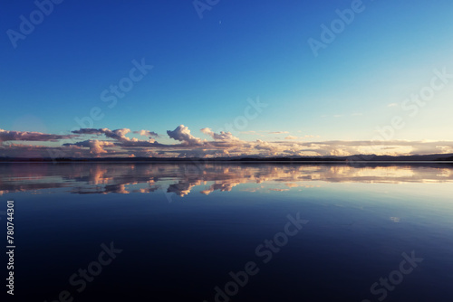 Clouds in the distance mirrored in the deep blue , calm water of Fern Ridge Reservoir in Oregon.