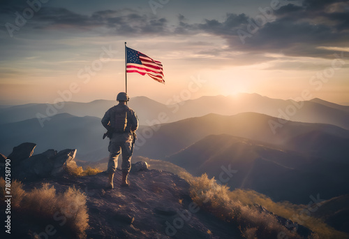 Patriotic soldier standing with the American flag on a mountain at sunrise, overlooking a scenic landscape with rolling hills and a golden sky. photo