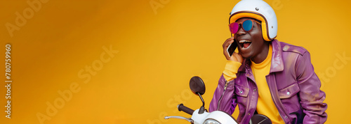 funny and loud young african man, he is on the phone and riding a fast scooter at the same time, he is wearing modern yellow and purple casual clothes and a scooter helmet, plain yellow background photo