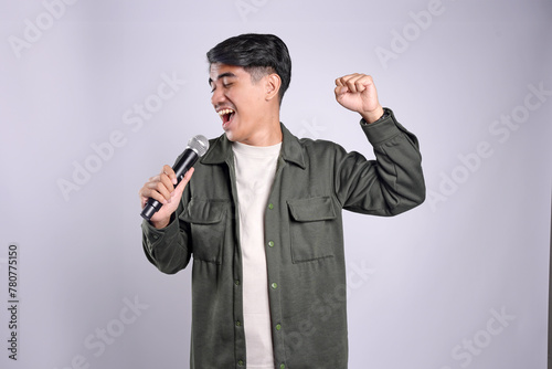 Stylist asian men singing songs with microphone, holding mic and dancing at karaoke isolated white background.