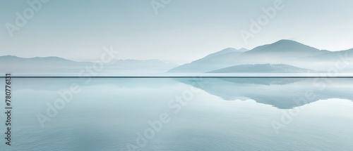   A scene of a sizable water body, backed by mountains, and a foreground fog-filled sky © Jevjenijs