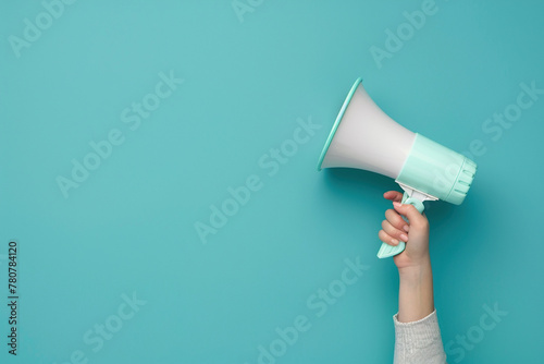 Hand Holding Megaphone on Solid Blue Background