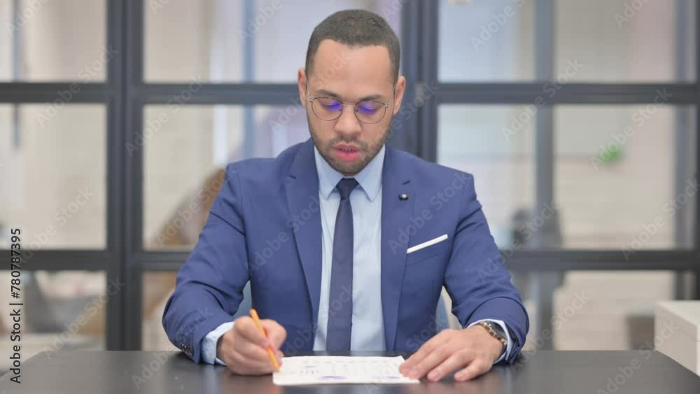 Mixed Race Businessman Working on Documents in Office Mixed Race Businessman Working on Documents in Office