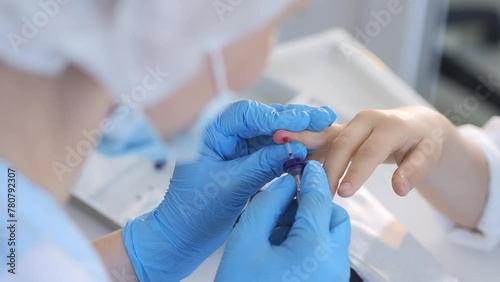 A doctor takes a patient's blood sample from a finger prick. Child's blood test. Blood test, blood group determination and medicine concept photo