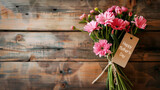 Bouquet of pink gerberas daisy flowers on wooden planks background with copy space, Happy Mother's Day written on a paper label tag