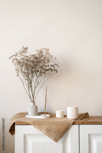 Dried flower vase on wood table with candles, creating a serene interior design, vertical home background with free copy space