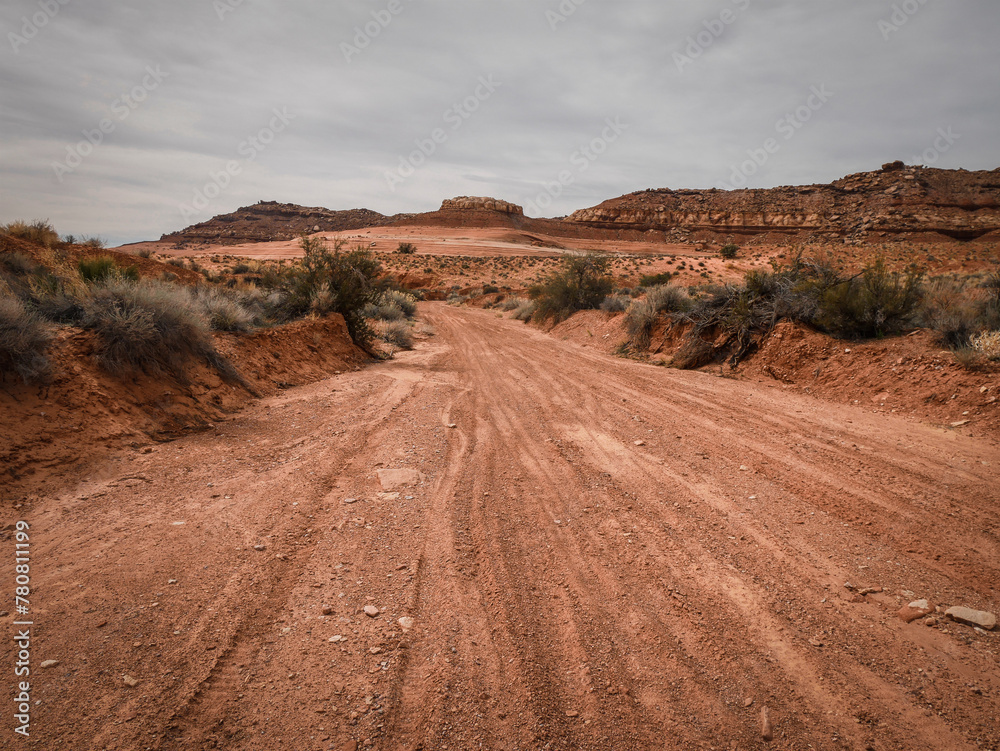 Sandy wash through red desert terrain with hills and sandstone features near Moab Utah