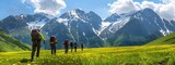 A group of hikers with backpacks and walking sticks are hiking in the mountains, surrounded by green alpine meadows with yellow flowers.