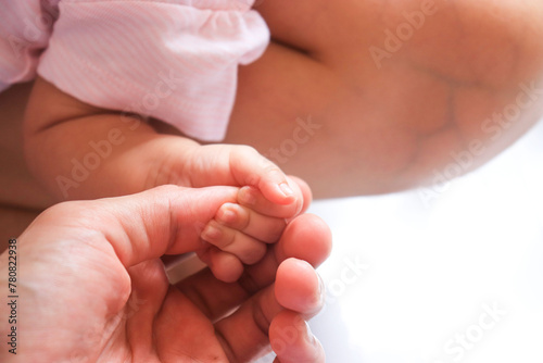 baby holding mother finger