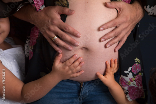 Family members hands touching holding their mother big pregnant belly family 
