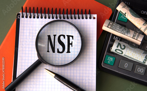 Photography NSF - acronym under magnifying glass on the background of calculator and banknot