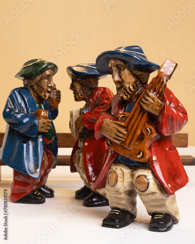Trio of musicians carved from wood on a clean background. Figures carved in wood. Handicrafts. Andean crafts.
