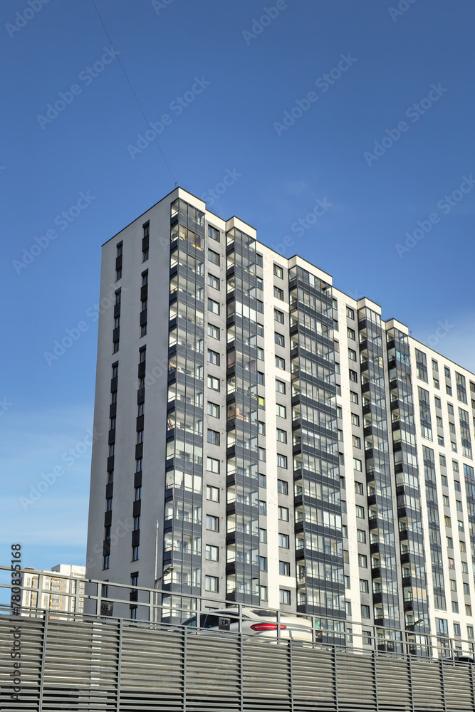 New grey high-rise building in a residential neighborhood.