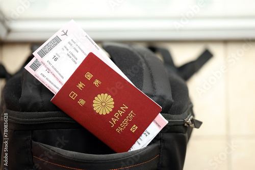 Japan passport with airline tickets on touristic backpack close up. Tourism and travel concept