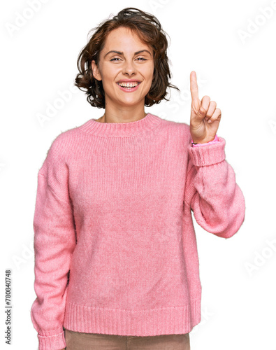 Young hispanic woman wearing casual clothes showing and pointing up with finger number one while smiling confident and happy.