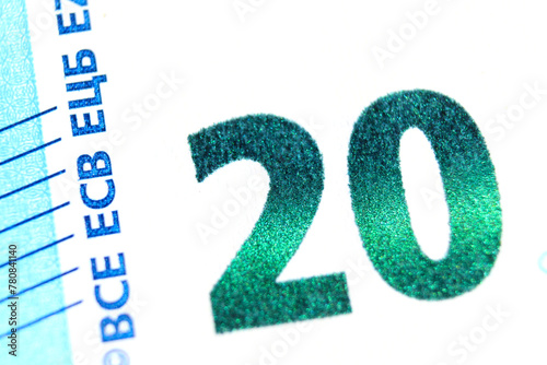 Close-up of a 20 euro banknote fragment showing the denomination - emerald number 20. Macro photography.