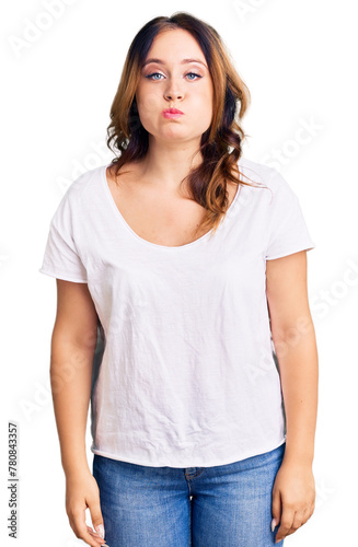 Young beautiful caucasian woman wearing casual white tshirt puffing cheeks with funny face. mouth inflated with air, crazy expression. © Krakenimages.com