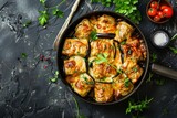 Top view of eggplant rolls with cheese and greens on dark stone background cooked in frying pan Flat lay