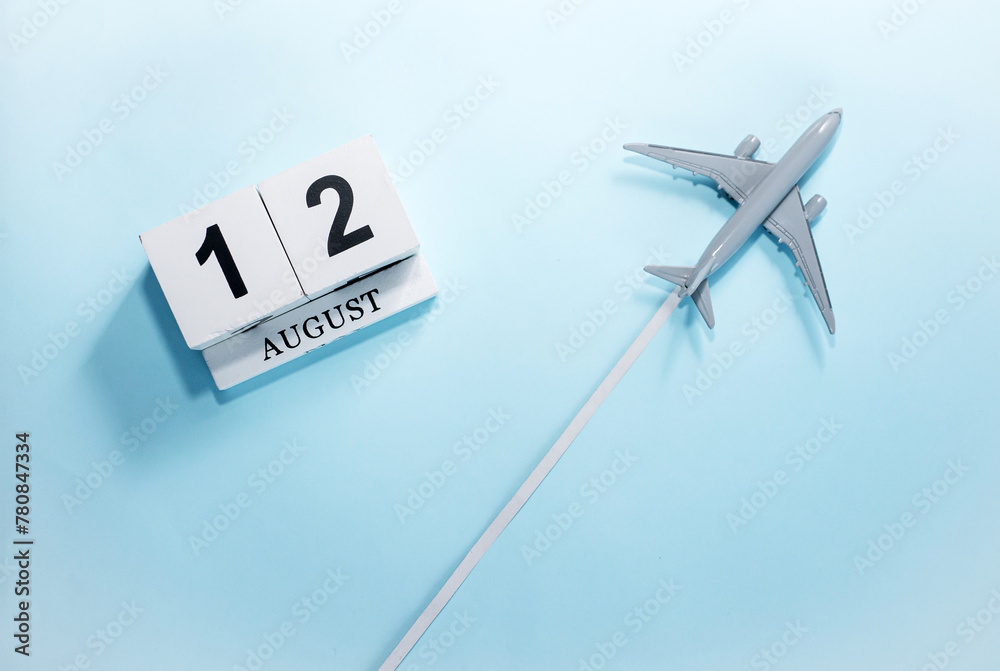 August calendar with number 12. Top view of a calendar with a flying passenger plane. Scheduler. Travel concept. Copy space. August calendar with number 12. Top view of a calendar with a flying passenger plane. Scheduler. Travel concept. Copy space.