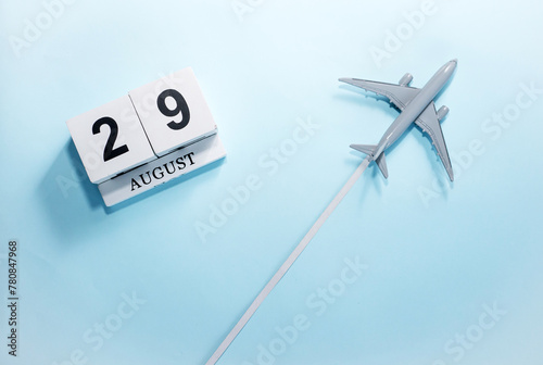 August calendar with number  29. Top view of a calendar with a flying passenger plane. Scheduler. Travel concept. Copy space. photo