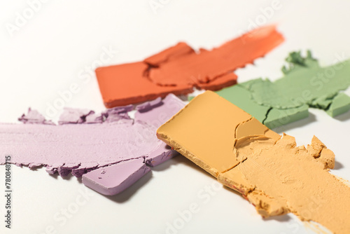Samples of different color correcting concealers on white background, closeup