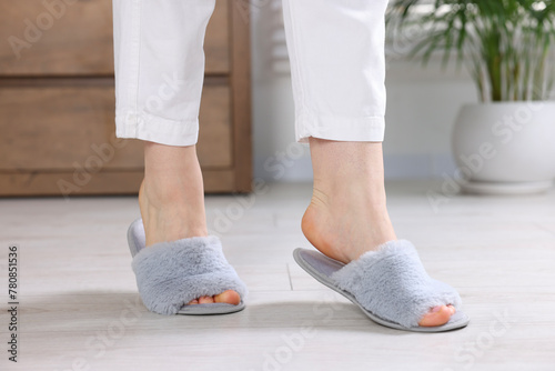 Woman in grey soft slippers at home, closeup © New Africa