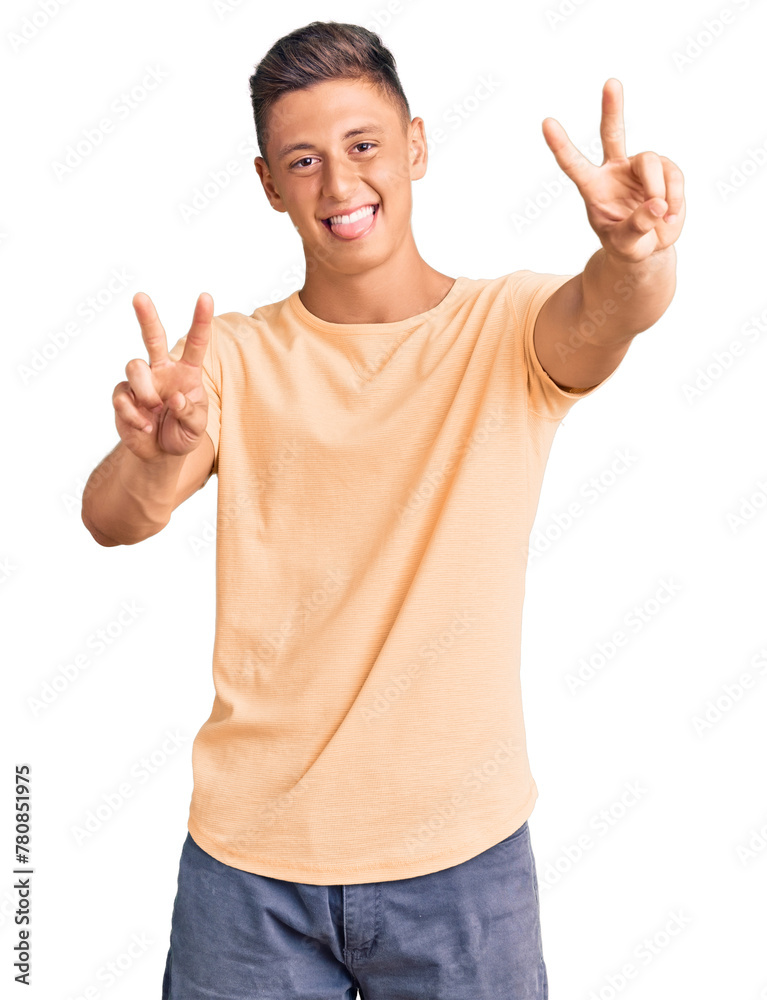 Young handsome man wearing casual clothes smiling with tongue out showing fingers of both hands doing victory sign. number two. Young handsome man wearing casual clothes smiling with tongue out showing fingers of both hands doing victory sign. number two.