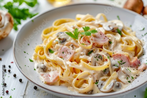 Fettuccine pasta with mushrooms and fried chicken in creamy cheese sauce on a wooden background