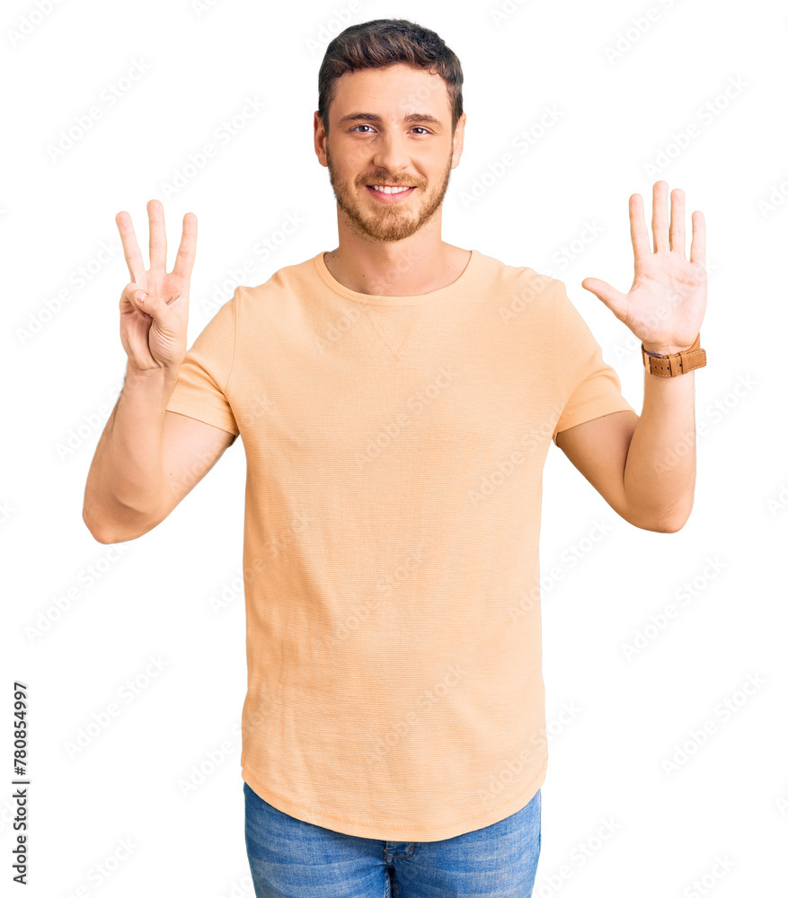 Fototapeta premium Handsome young man with bear wearing casual yellow tshirt showing and pointing up with fingers number eight while smiling confident and happy.