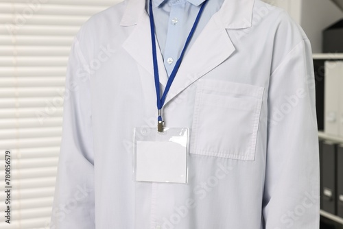 Doctor with empty badge in hospital, closeup