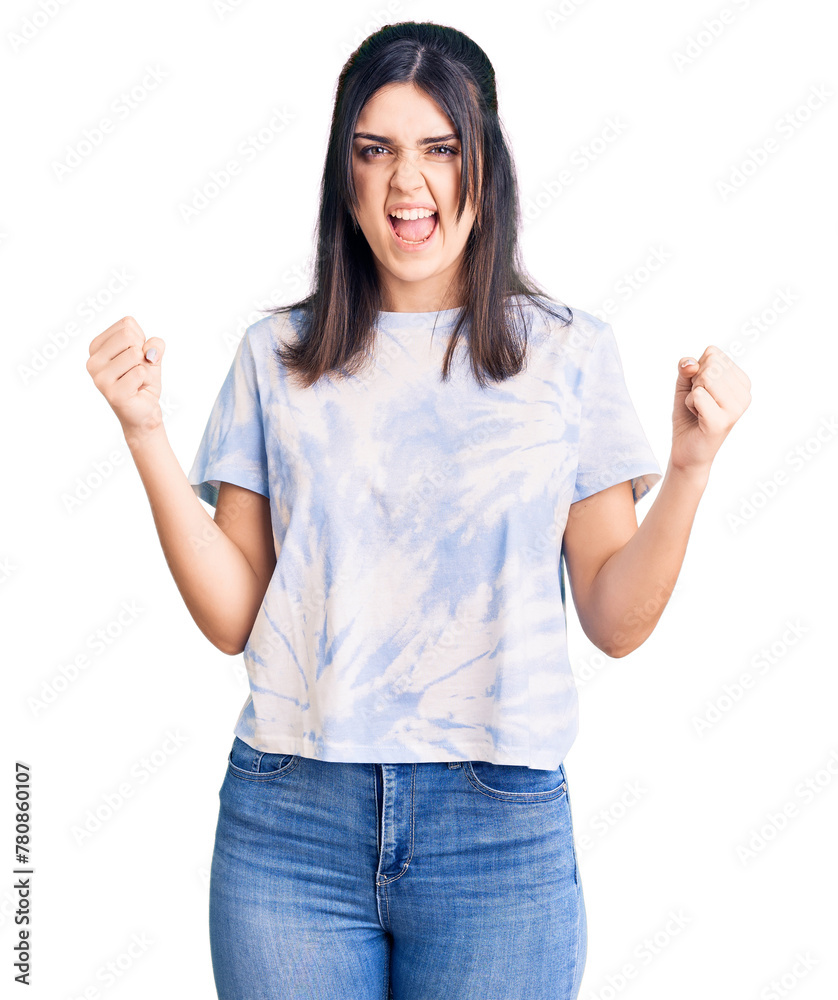 Young beautiful girl wearing casual t shirt angry and mad raising fists frustrated and furious while shouting with anger. rage and aggressive concept. Young beautiful girl wearing casual t shirt angry and mad raising fists frustrated and furious while shouting with anger. rage and aggressive concept.