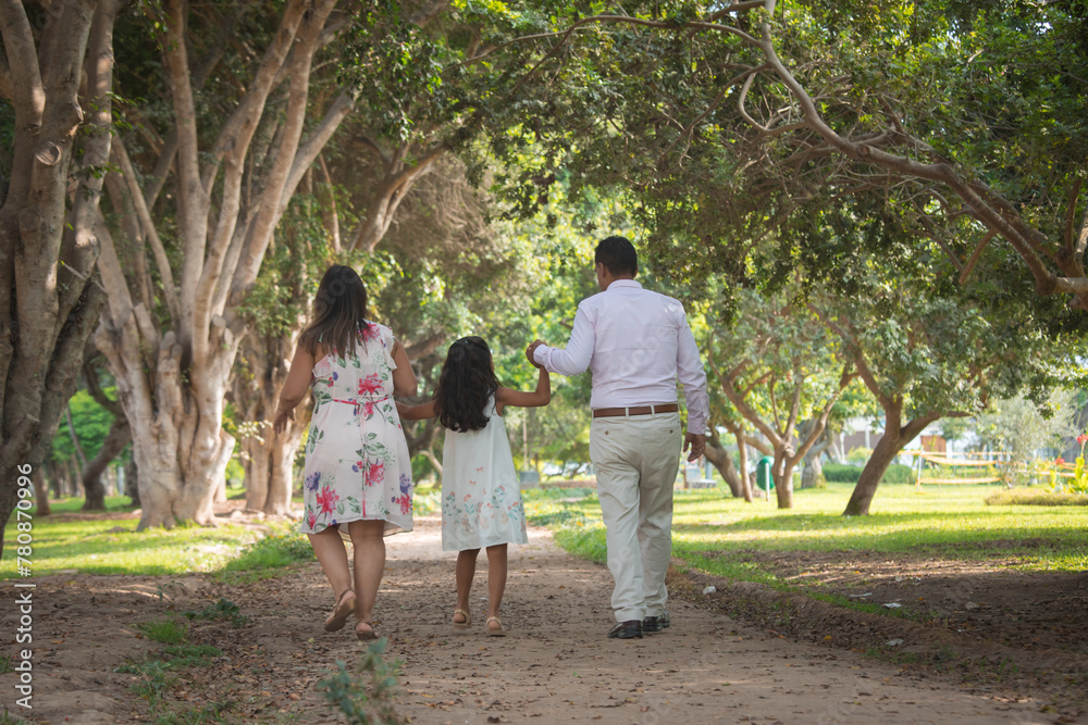 family walking in the park holding hands happily family walking in the park holding hands happily
