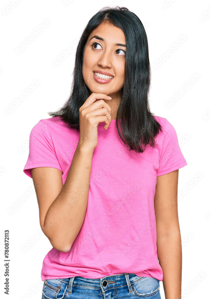 Beautiful asian young woman wearing casual pink t shirt with hand on chin thinking about question, pensive expression. smiling with thoughtful face. doubt concept. Beautiful asian young woman wearing casual pink t shirt with hand on chin thinking about question, pensive expression. smiling with thoughtful face. doubt concept.