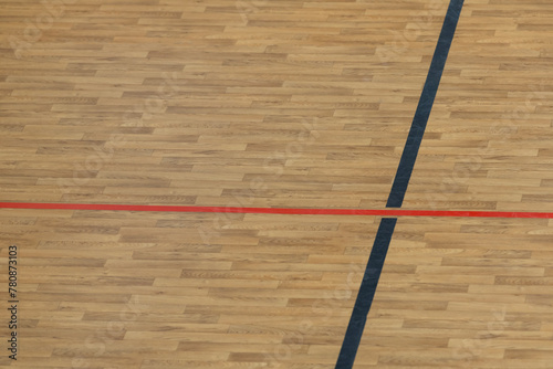 Wooden floor basketball, badminton, futsal, handball, volleyball, football, soccer court. Wooden floor of sports hall with red marking lines on wooden floor indoor, gym court