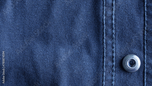 Blue denim background with metal button fastener and decorative stitches. Stitches with thread. Photo. Aspect ratio 18 to 9
