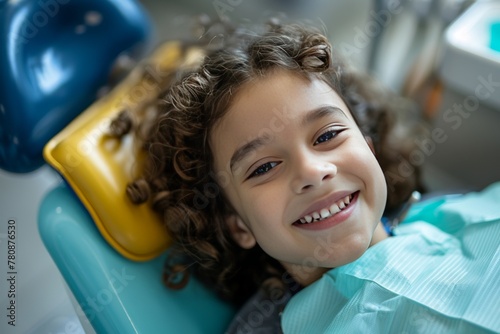 smiling girl 5 years old in the dentist's chair at a clinic appointment photo