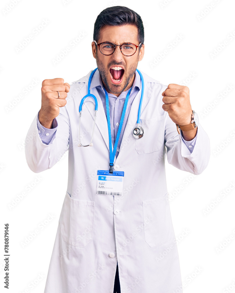 Young hispanic man wearing doctor uniform and stethoscope angry and mad raising fists frustrated and furious while shouting with anger. rage and aggressive concept. Young hispanic man wearing doctor uniform and stethoscope angry and mad raising fists frustrated and furious while shouting with anger. rage and aggressive concept.