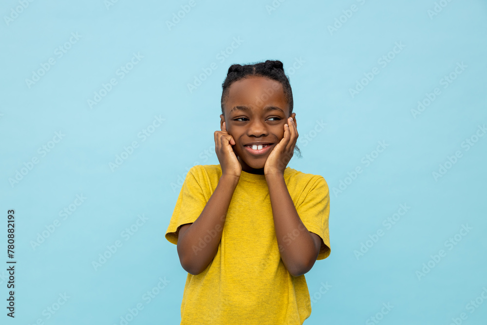 Smiling dark- skinned little boy covering his ears Smiling dark- skinned little boy covering his ears