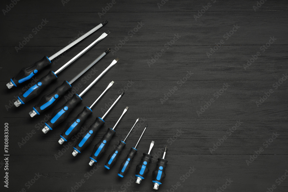 Set of screwdrivers on black wooden table, top view. Space for text Set of screwdrivers on black wooden table, top view. Space for text