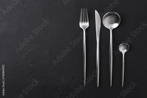 Beautiful cutlery set on black table, flat lay. Space for text