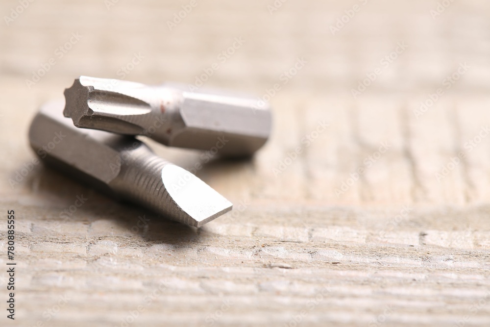 Different screwdriver bits on wooden table, closeup. Space for text Different screwdriver bits on wooden table, closeup. Space for text