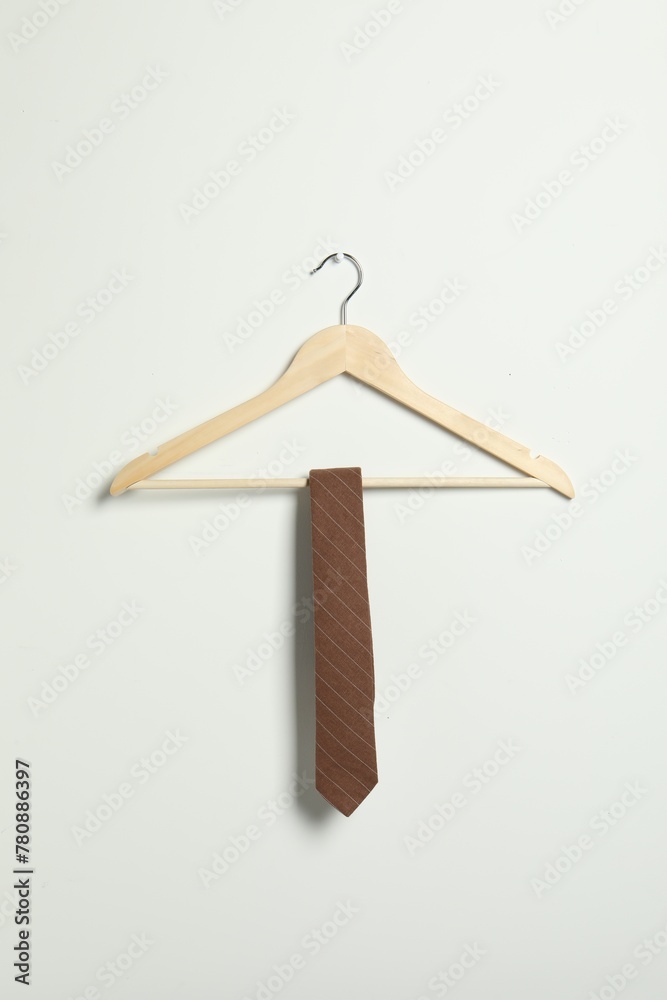 Fototapeta premium Hanger with striped necktie on white wall