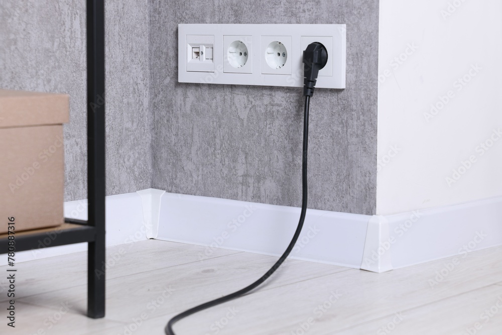 Power sockets and electric plug on grey wall - obrazy, fototapety, plakaty 
