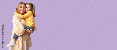 Little girl is in her mother's arms on lilac background. Mother's Day