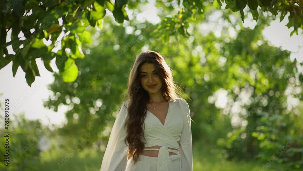 Beautiful woman with flowers in summer garden in white dress on green background. Concept of nature, beauty, harmony Beautiful woman with flowers in summer garden in white dress on green background. Concept of nature, beauty, harmony