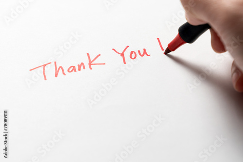 Hand written thank you message with a red pen on white background, gratitude concept. © Kenishirotie
