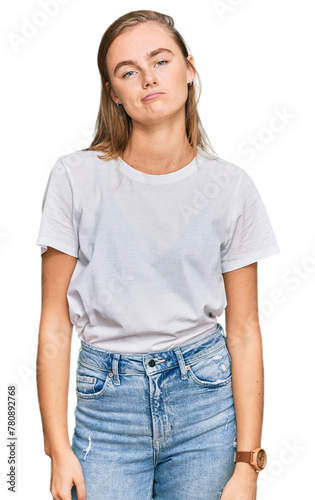 Beautiful young blonde woman wearing casual white t shirt looking sleepy and tired, exhausted for fatigue and hangover, lazy eyes in the morning.