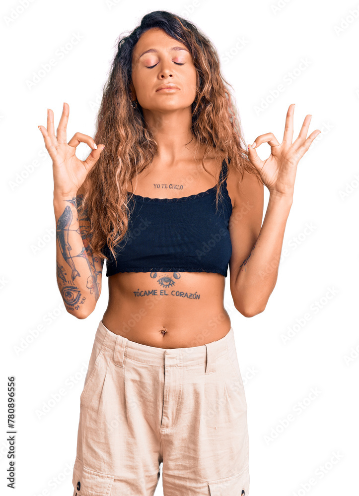 Young hispanic woman with tattoo wearing casual clothes relax and smiling with eyes closed doing meditation gesture with fingers. yoga concept. Young hispanic woman with tattoo wearing casual clothes relax and smiling with eyes closed doing meditation gesture with fingers. yoga concept.