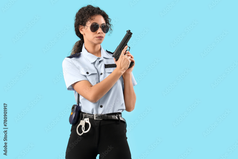 African-American female police officer with gun on blue background African-American female police officer with gun on blue background