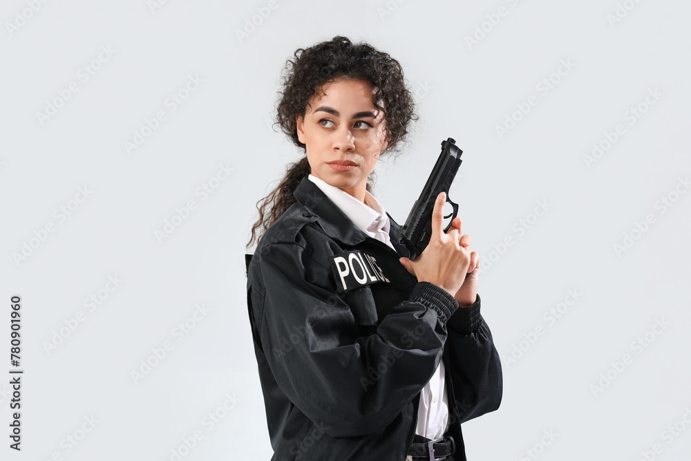 African-American female police officer with gun on white background African-American female police officer with gun on white background